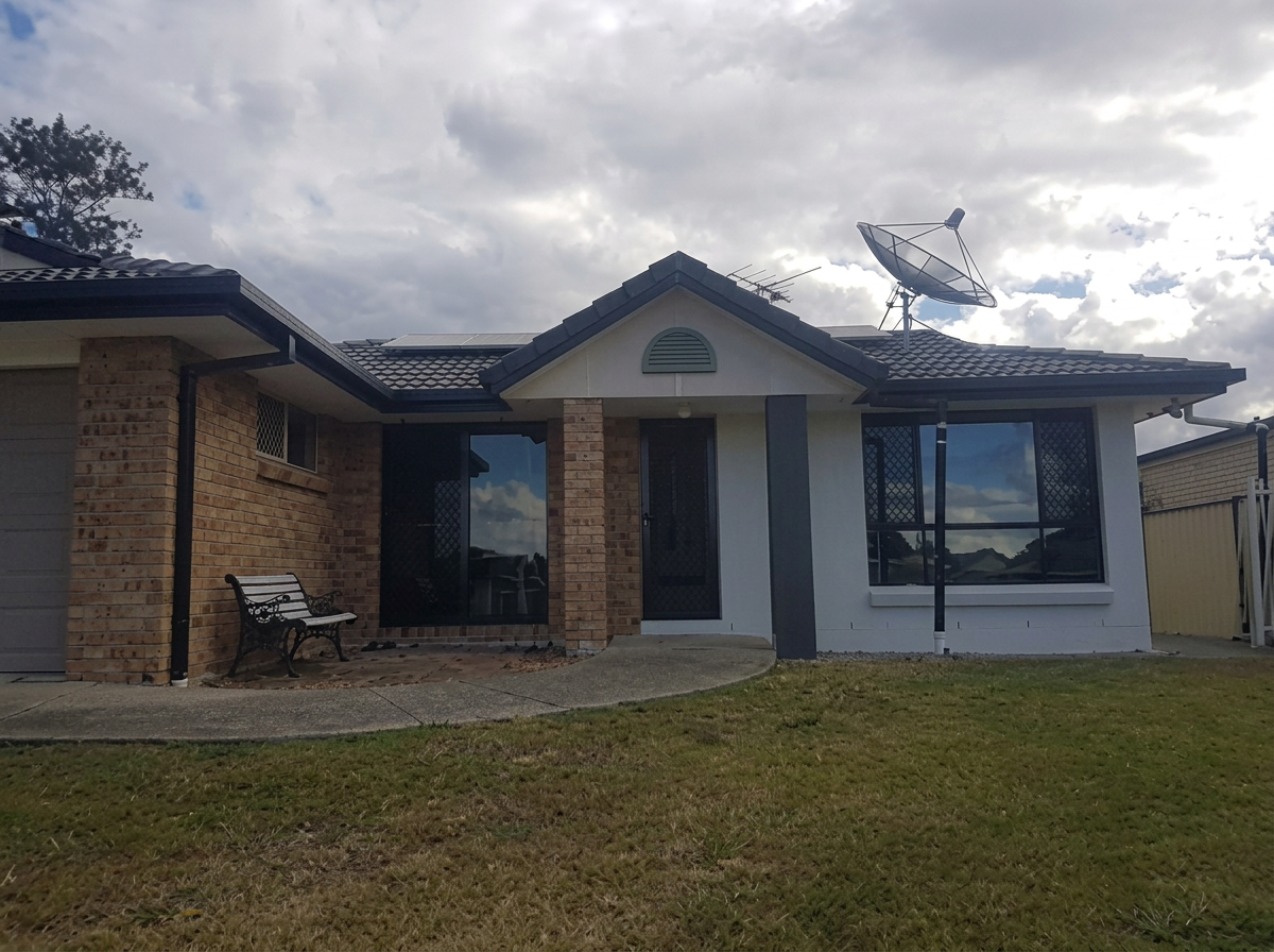 Brick home transformed with white render and dark trim