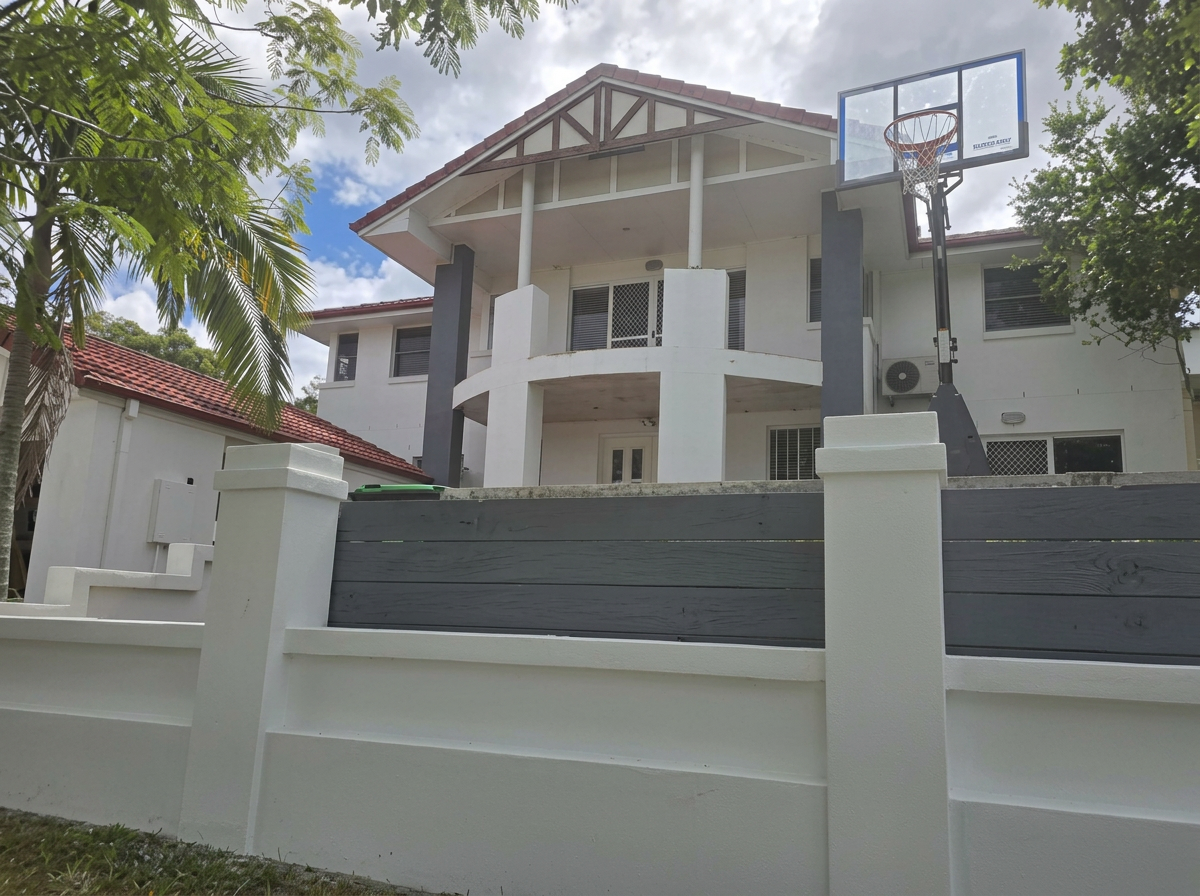 Two-storey home with feature rendered fence and crisp white walls
